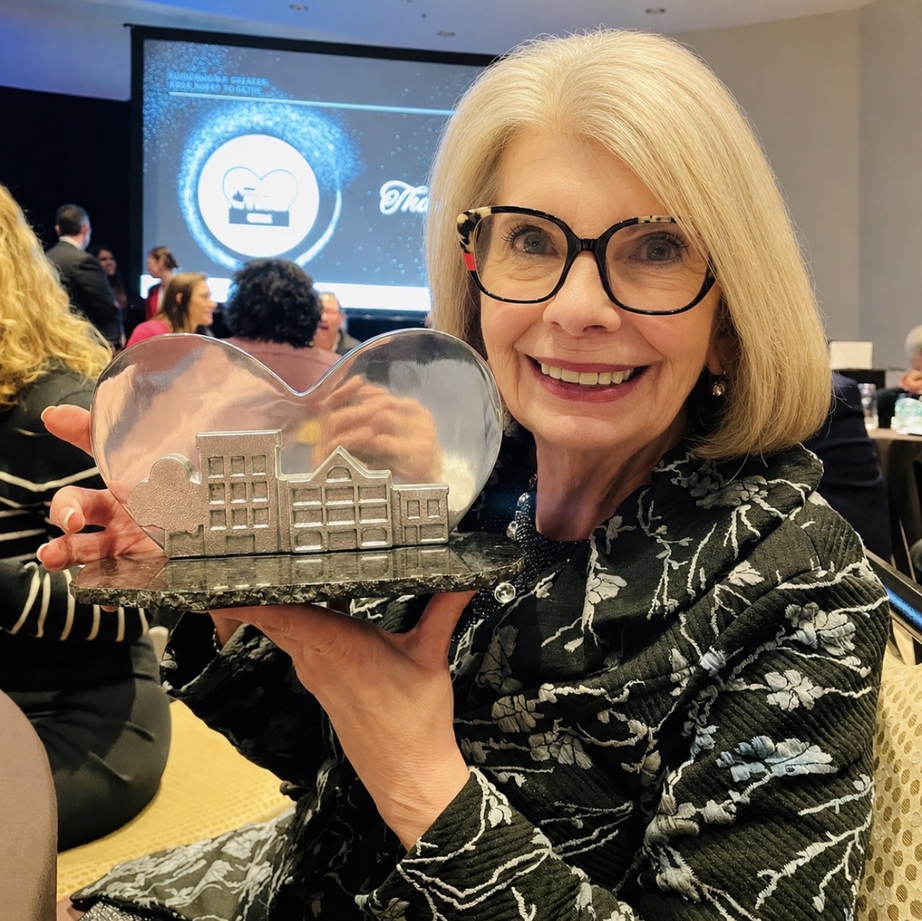 Ellen Timms holding a lifetime achievement award at an industry celebration